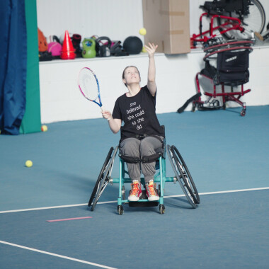 Wheelchair tennis player serving in game