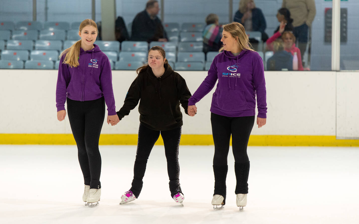 Three women on an ice rink.