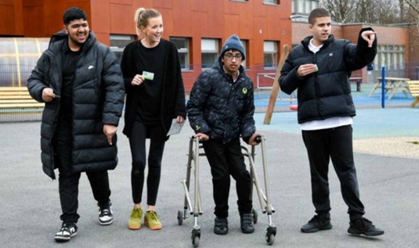 A group of people, including one boy using a frame, play the walking game Beat the Street.