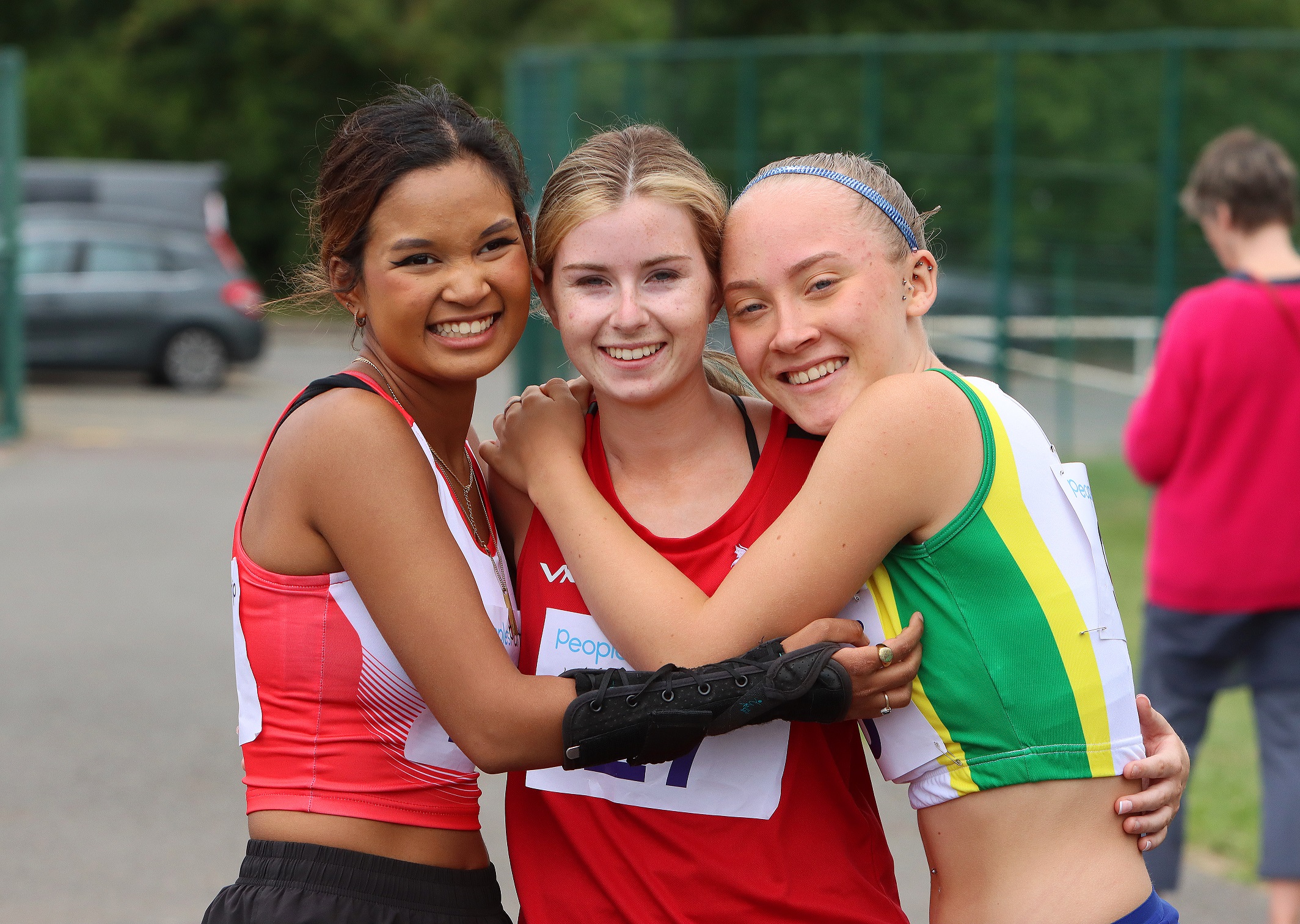 3 young disabled athletes hugging after event